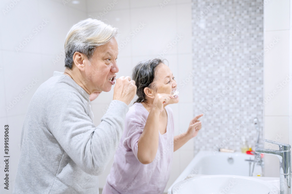 Obraz premium Elderly couple brushing their teeth in bathroom
