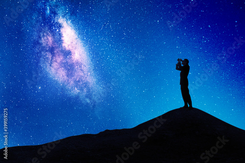 Male manager looks at milky way through binoculars