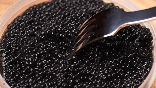 gourmet paddlefish black caviar and metal fork, close up