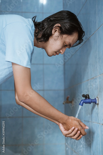 Man muslim perform ablution (wudhu) washing hand before prayer. photo