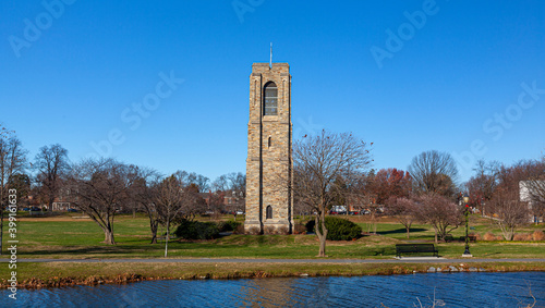 Baker Park, a city park by Carrol Creek with large open meadows, trees, walking and cycling paths and the famous historic  tower and carillon. Image shows Frederick cityscape with the river. photo