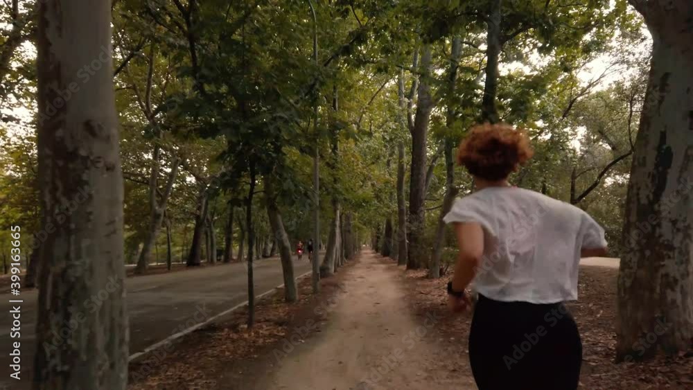 A shot following a running woman on a dirt road nedt to a bike road as they pass her A shot following a running woman on a dirt road nedt to a bike road as they pass her
