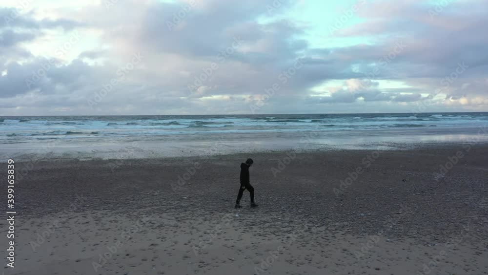 Man walks alone along empty deserted beach during pandemic Covid-19 Man walks alone along empty deserted beach during pandemic Covid-19