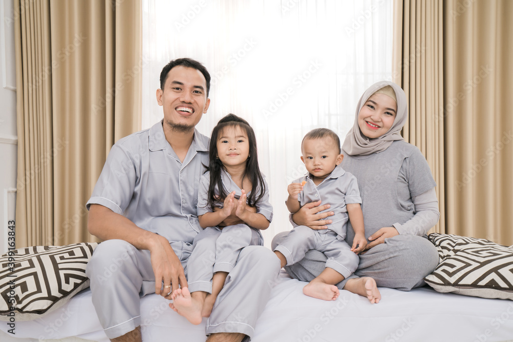 Portrait of a happy family in piyama clothes. Family photo concept in bedroom