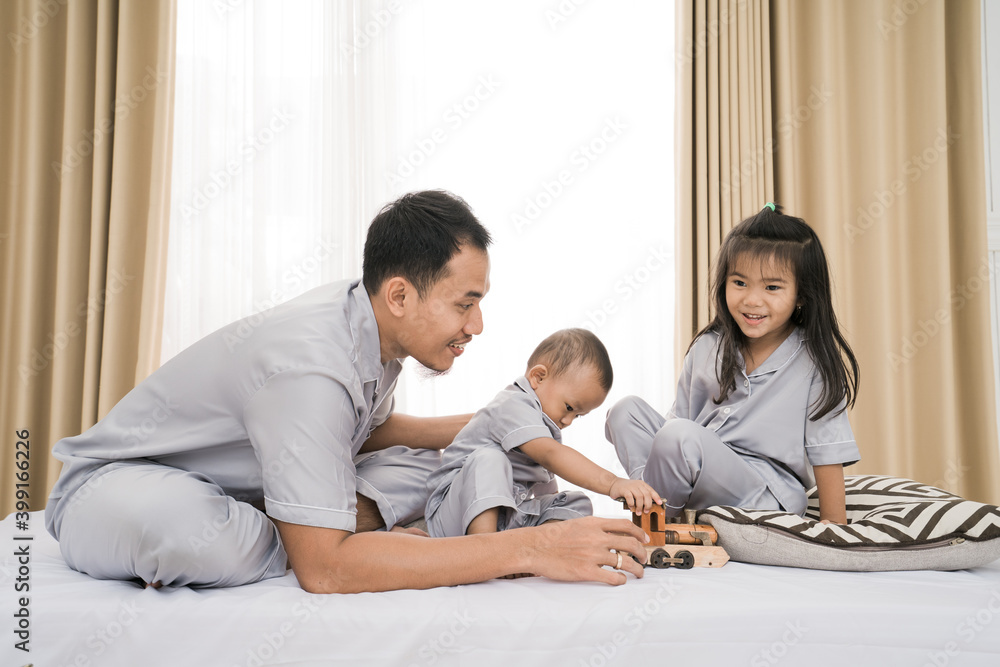Portrait of a father playing with his children in bedroom Portrait of a father playing with his children in bedroom