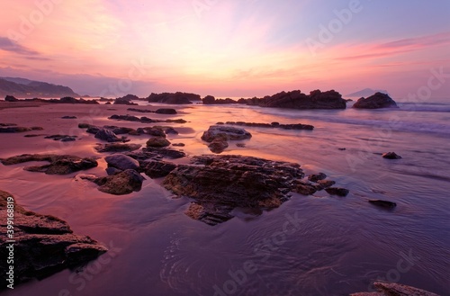 Sunrise scenery of a beautiful rocky beach on northern coast of Taiwan with an island on distant horizon under dramatic dawning sky & golden sunlight reflecting on the seawater (Long Exposure Effect) © AaronPlayStation