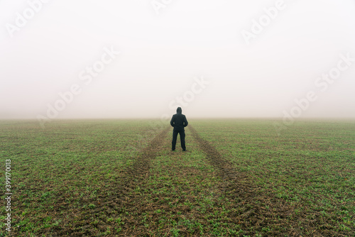 Man on the path disappearing in fog 