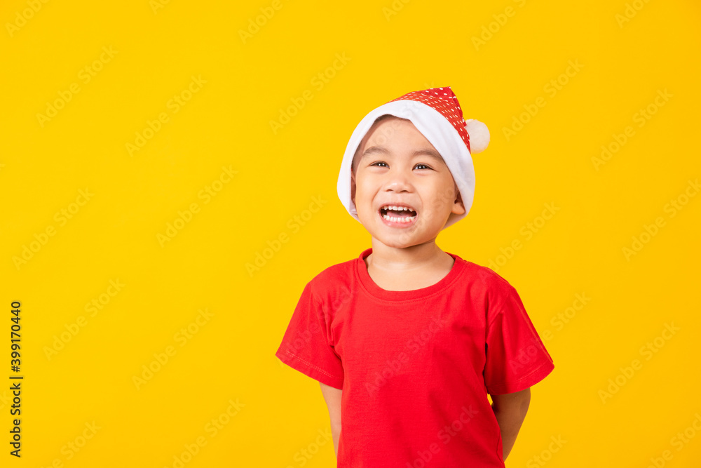 Kid dressed in red Santa Claus hat, Portrait of Asian little cute boy smile and excited the concept of holiday Christmas Xmas day or Happy new year, studio shot isolated on yellow background Kid dressed in red Santa Claus hat, Portrait of Asian little cute boy smile and excited the concept of holiday Christmas Xmas day or Happy new year, studio shot isolated on yellow background