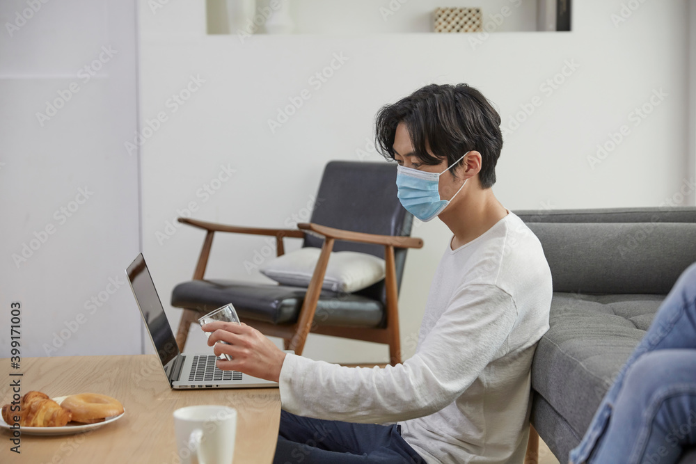 마스크를 쓰고 재택근무를 하는 남성 마스크를 쓰고 재택근무를 하는 남성