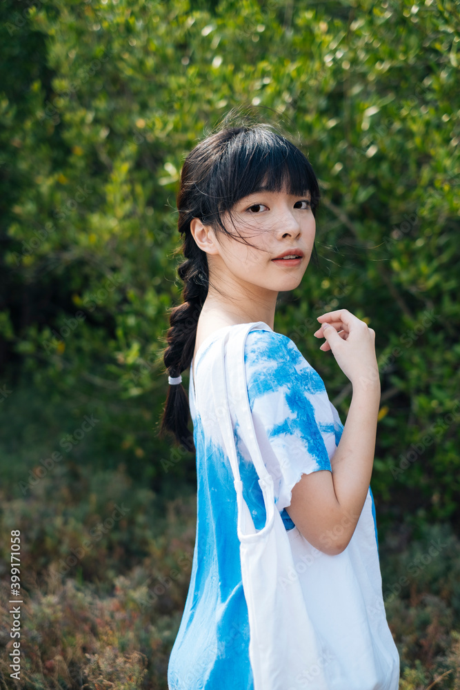 Asian woman wear blue dress with white canvas bag in nature. Asian woman wear blue dress with white canvas bag in nature.
