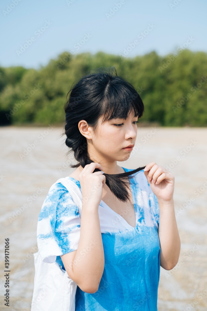 Asian woman wear blue dress playing with her hair. Asian woman wear blue dress playing with her hair.
