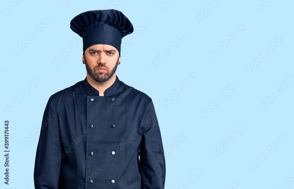 Young hispanic man wearing cooker uniform skeptic and nervous, frowning upset because of problem. negative person. Young hispanic man wearing cooker uniform skeptic and nervous, frowning upset because of problem. negative person.