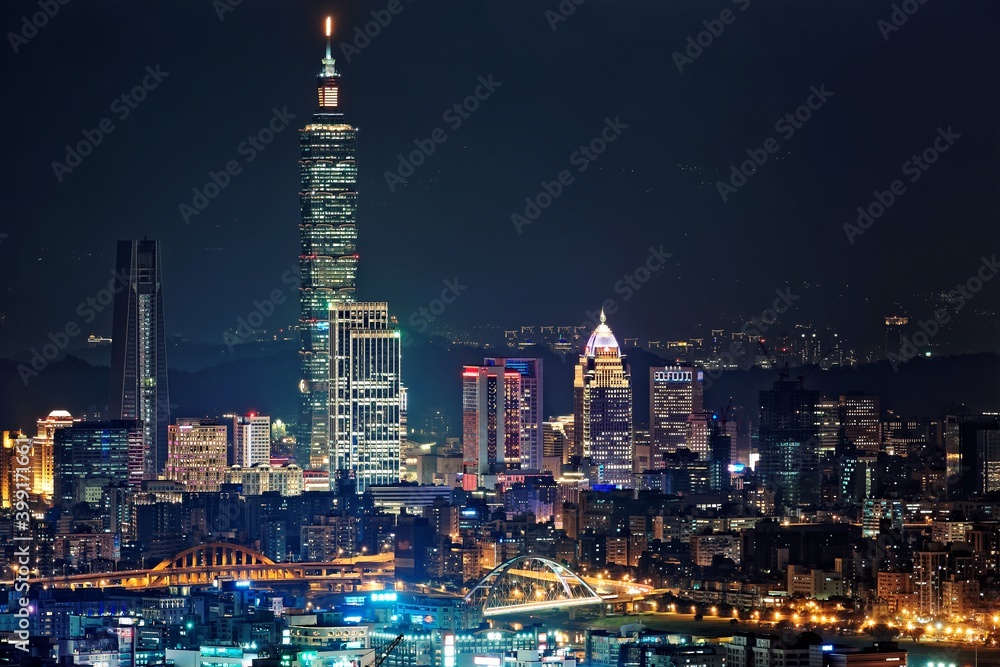 Night scenery of Downtown Taipei, the vibrant capital city of Taiwan, with view of Taipei 101 Tower standing among high-rise buildings in Xinyi Financial District and city lights dazzling in the dark
