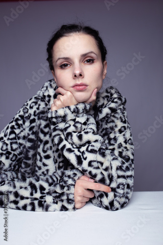 woman in hoodie, studio portrait on gray background
