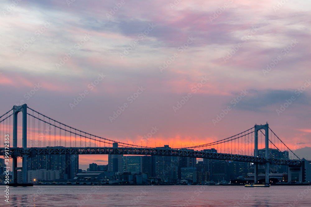 Bridge and buildings against the the red sky after sundown