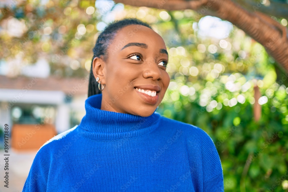 Young african american woman smiling happy walking at the park. Young african american woman smiling happy walking at the park.