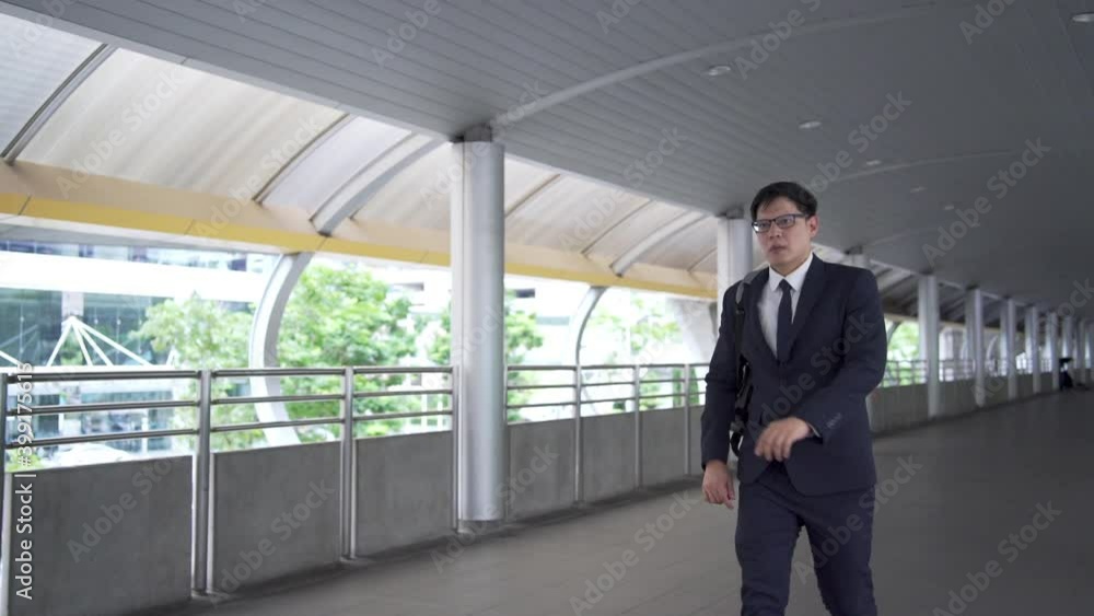 Confidence Asian businessman office worker in suit with backpack walking in rush hour at railway station to work in the morning. Business people hurry up going to working at city office district Confidence Asian businessman office worker in suit with backpack walking in rush hour at railway station to work in the morning. Business people hurry up going to working at city office district