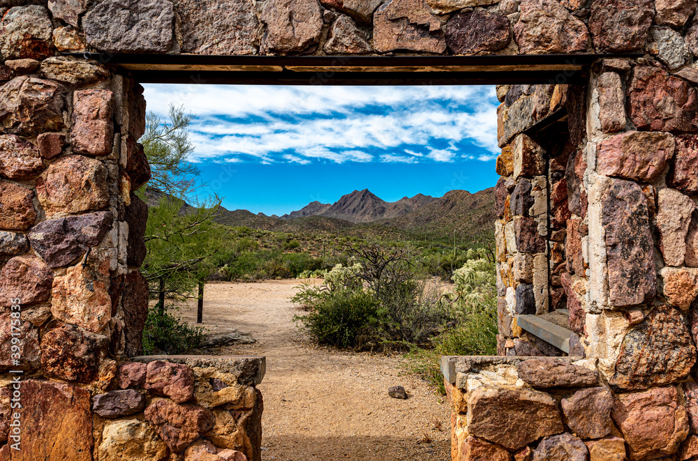 Looking through the window at the picturesque desert landscape from the ruins of a stone house on the Bowen Trail in Tucson Arizona.