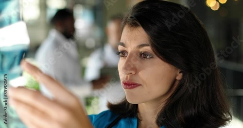 Wallpaper Mural Close up of Caucasian beautiful unsatisfied young woman doctor holding x-ray and examining it in hospital. Mixed-races doctors on background. Female physician working in clinic. Medicine concept. Torontodigital.ca