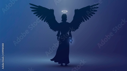 Silhouette of an angel in the dark with a bible in hand