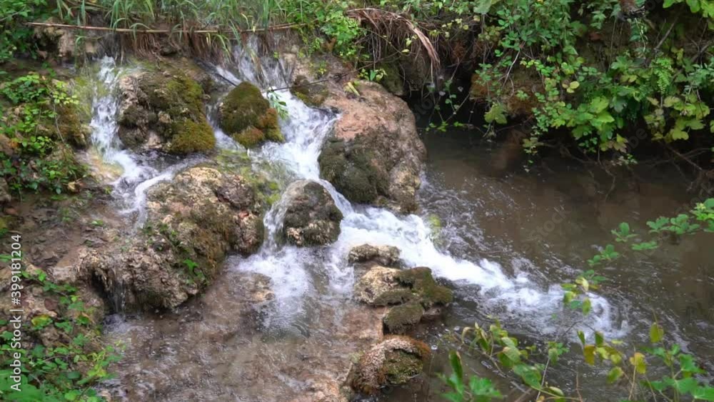 Water flowing past large moss covered rocks at Krka National Park in Croatia at ¼ speed Water flowing past large moss covered rocks at Krka National Park in Croatia at ¼ speed