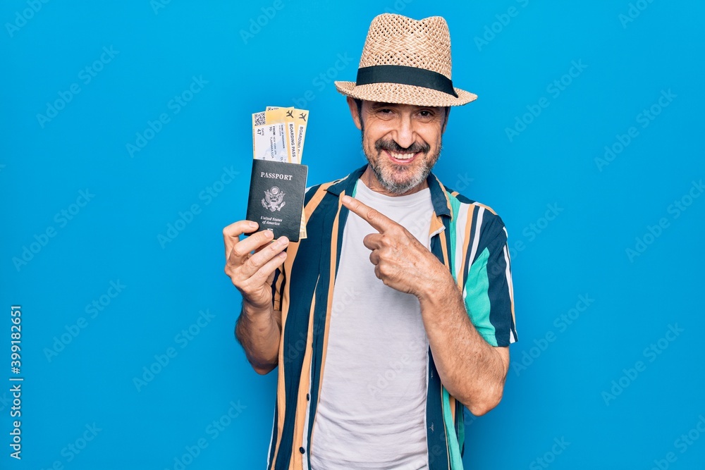 Middle age tourist man on vacation holding united states passport with boarding pass smiling happy pointing with hand and finger Middle age tourist man on vacation holding united states passport with boarding pass smiling happy pointing with hand and finger