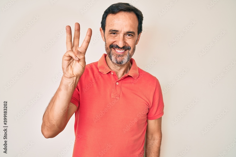 Middle age hispanic man wearing casual clothes showing and pointing up with fingers number three while smiling confident and happy. Middle age hispanic man wearing casual clothes showing and pointing up with fingers number three while smiling confident and happy.