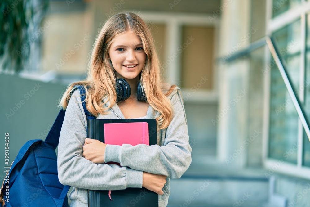 Beautiful caucasian student teenager smiling happy using headphones at the city. Beautiful caucasian student teenager smiling happy using headphones at the city.