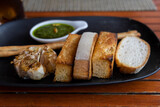Italian bread with grilled garlic and herb oil on a black plate