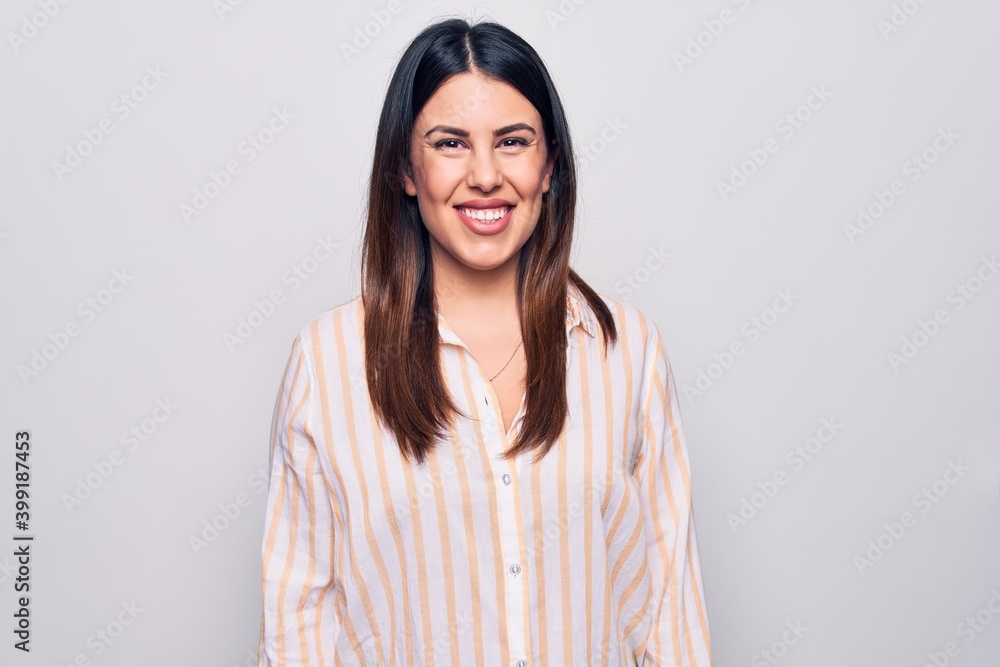 Young beautiful brunette woman wearing casual striped shirt standing over white background with a happy and cool smile on face. Lucky person. Young beautiful brunette woman wearing casual striped shirt standing over white background with a happy and cool smile on face. Lucky person.
