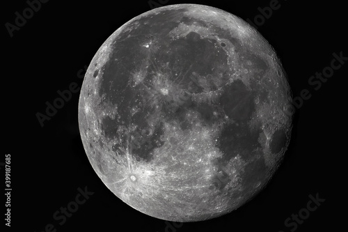 Photo of the moon through a telescope. Moon with craters on a dark background.