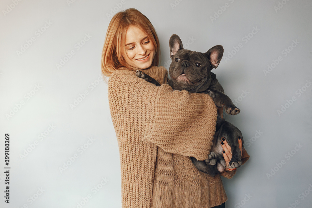 Woman with dog. Lady in a browm sweater. Girl play with bulldog.