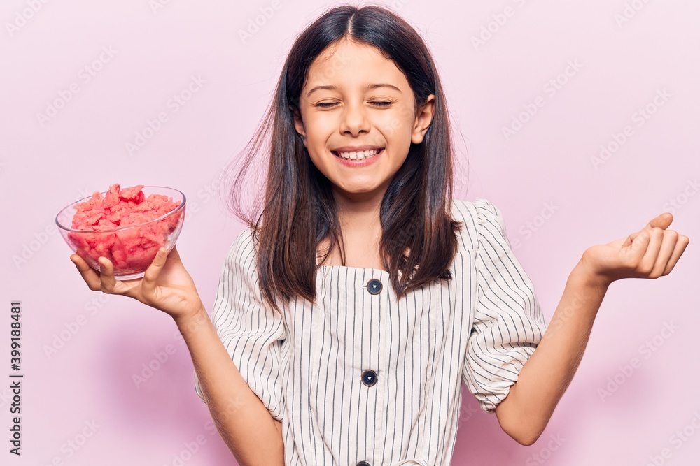Beautiful child girl holding ice cream screaming proud, celebrating victory and success very excited with raised arm Beautiful child girl holding ice cream screaming proud, celebrating victory and success very excited with raised arm