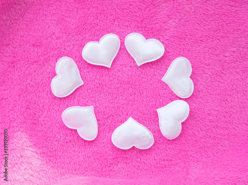 White hearts on pink delicate soft background of plush fabric.  St. Valentine s celebration  romantic concept. copy space