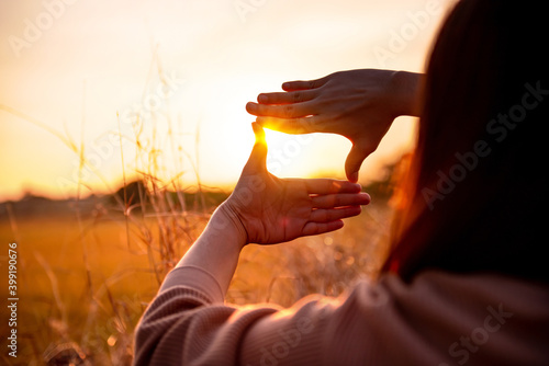 Future planning concept, Close up of woman hands making frame gesture with sunset, Female capturing the sunrise. photo