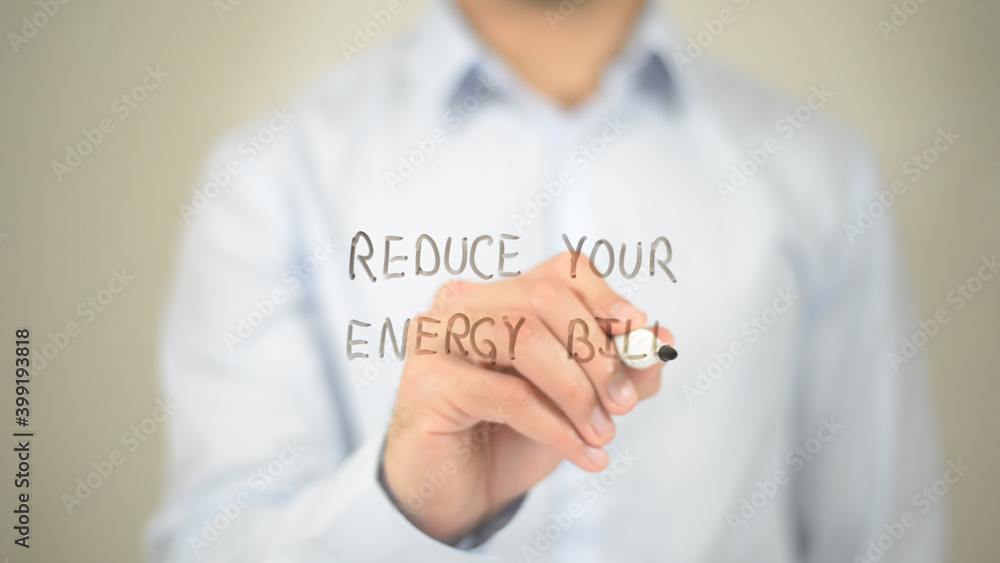 Reduce Your Energy Bill, man writing on transparent screen Reduce Your Energy Bill, man writing on transparent screen