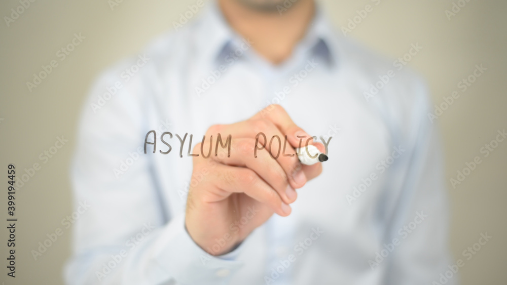 Asylum Policy , man writing on transparent screen Asylum Policy , man writing on transparent screen