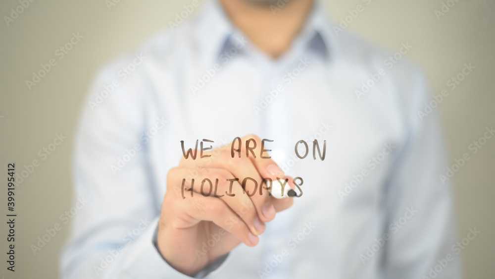 We Are On Holidays , man writing on transparent screen We Are On Holidays , man writing on transparent screen