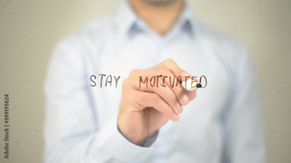 Stay Motivated, man writing on transparent screen Stay Motivated, man writing on transparent screen