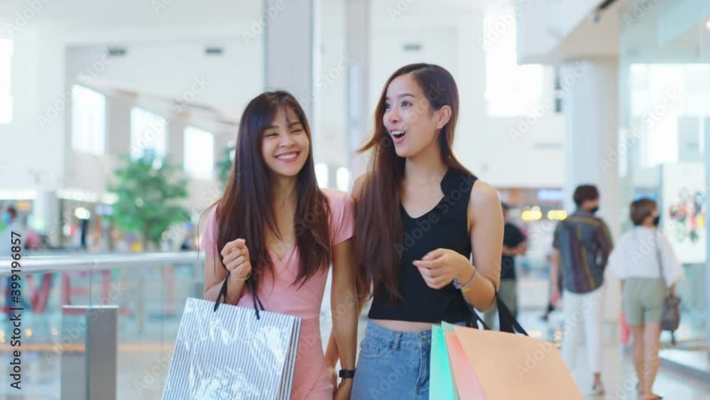Two Asian young women enjoy shopping and walking in department store. Two Asian young women enjoy shopping and walking in department store.