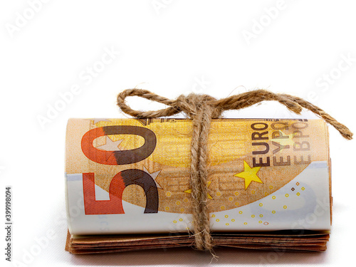 Several 50 Euro bills rolled up and tied with a tourniquet. Close-up, white background. The concept of cash.