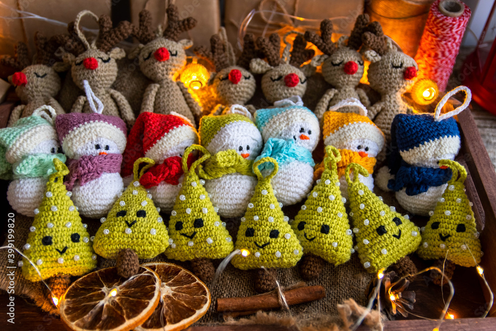A set of handmade Christmas tree toys crocheted in a wooden tray with burlap. Country style.
