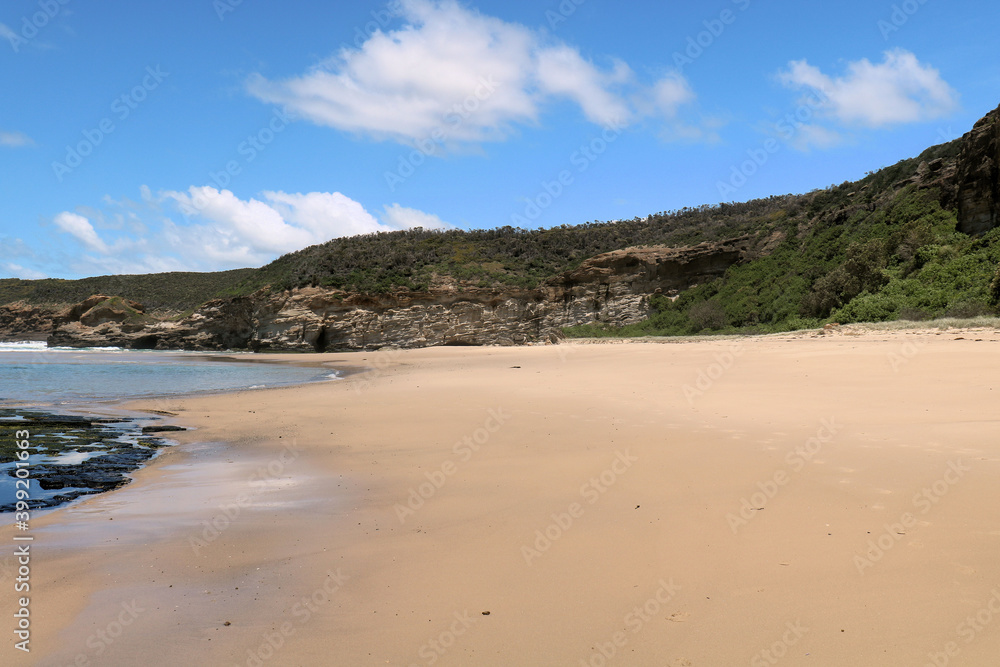 Ghosties Beach Catherine Hill Bay New South Wales Australia. The waves are washing over a sandy beach with cliffs in the background