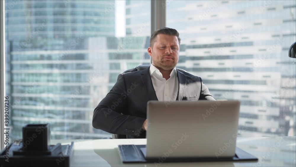 Professional businessman or lawyer working in his office through a modern computer. Cabinet on the background of skyscrapers. A businessman communicates via a laptop in his office. Professional businessman or lawyer working in his office through a modern computer. Cabinet on the background of skyscrapers. A businessman communicates via a laptop in his office.