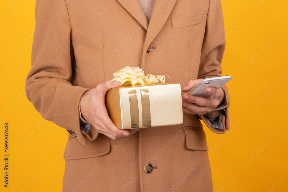 closeup of hands with gift box and mobile phone closeup of hands with gift box and mobile phone