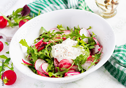 Vegetarian vegetable salad of radish and arugula with sour cream. Healthy vegan food.