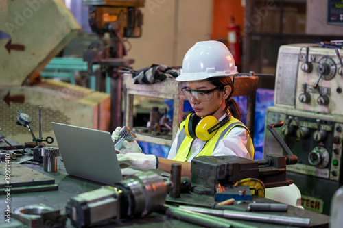 Industry worker woman under inspection and checking production at factory by laptop.