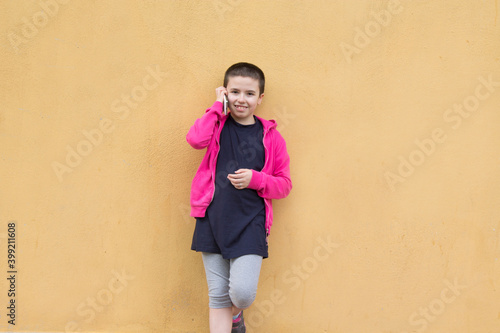 girl talking on the mobile phone on the yellow wall