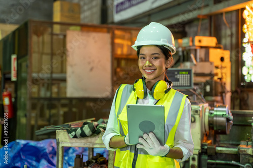 Industry engineer woman using a digital tablet checking production at factory.