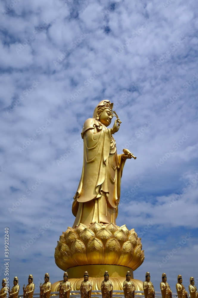 Fototapeta premium Great brass goddess Guanyin in a prayer position against a blue sky background at the Chinese temple Fo Guang Shan Thaihua Temple, a branch temple from Taiwan at Khubon Klong Sam Wa District, Bangkok 